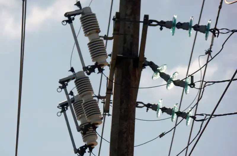 Drop-out fuse cutouts on a utility pole.png